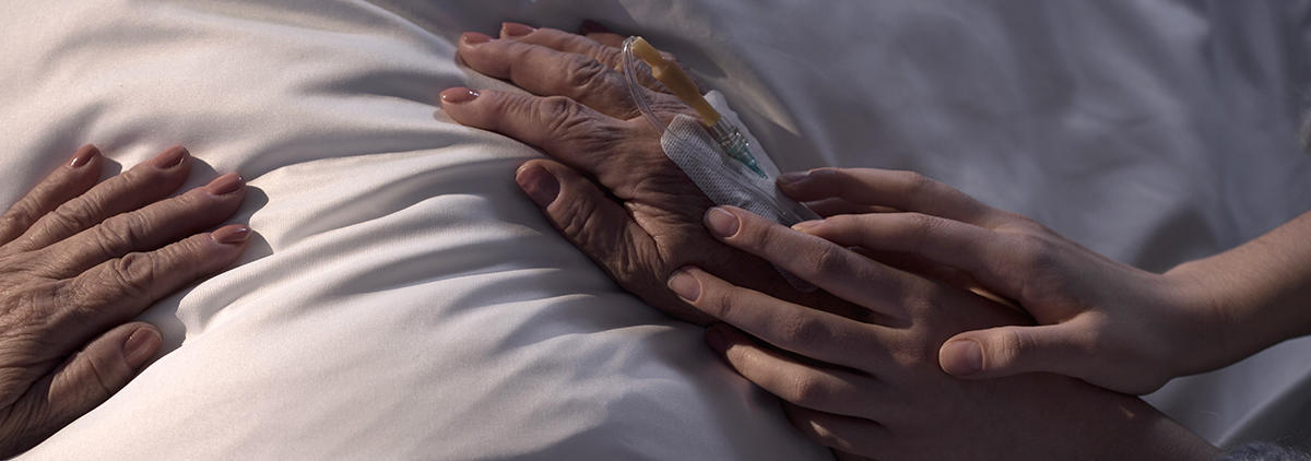 Todesfall_Ratgeber       -  Daughter touching hands of her ill mum